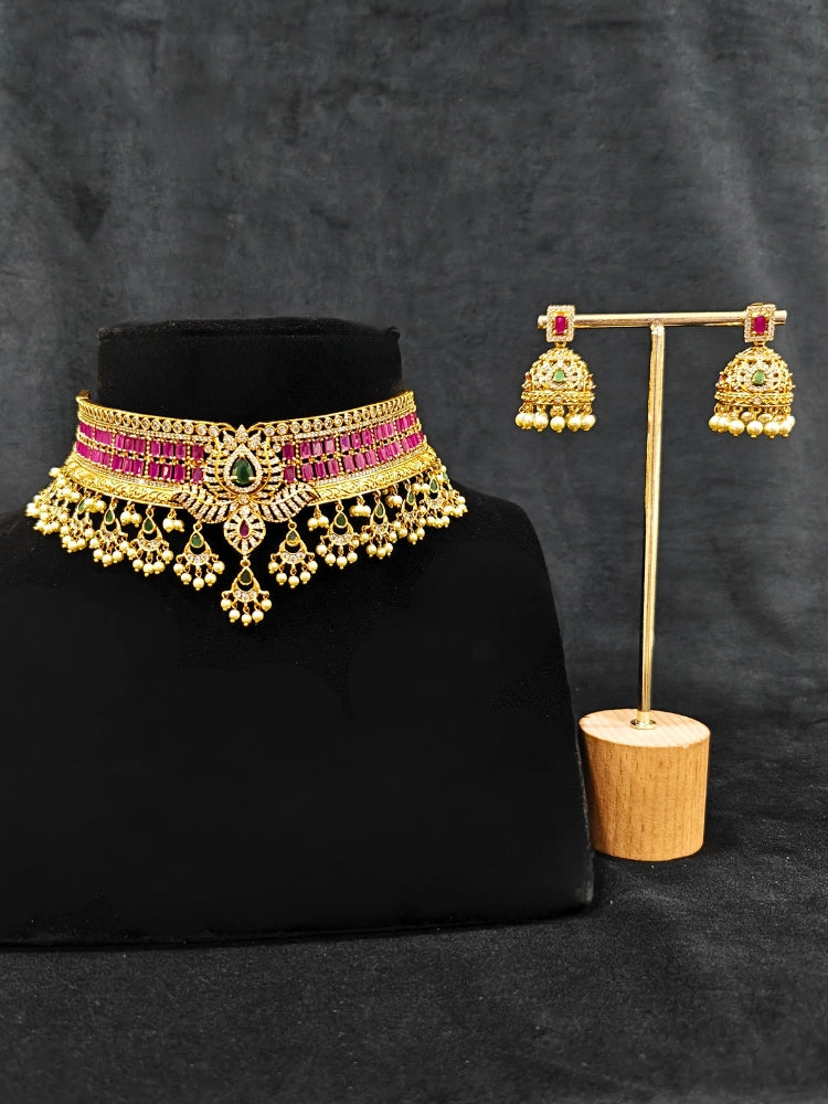 Close-up of an ornate traditional American Diamond gold Pink Choker jewellery set and earrings with  Colored Stones, American Diamond and Pearls. Close-up shot of a high-quality American diamond artificial necklace worn for festive celebrations. A sparkling American diamond necklace for her reception night.