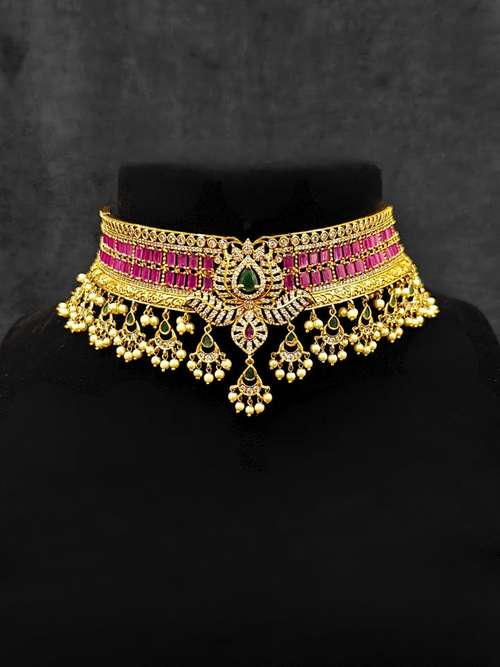Close-up of an ornate traditional American Diamond gold Pink Choker jewellery set and earrings with  Colored Stones, American Diamond and Pearls. Close-up shot of a high-quality American diamond artificial necklace worn for festive celebrations. A sparkling American diamond necklace for her reception night.