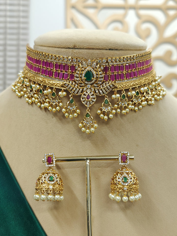 Close-up of an ornate traditional American Diamond gold Pink Choker jewellery set and earrings with  Colored Stones, American Diamond and Pearls. Close-up shot of a high-quality American diamond artificial necklace worn for festive celebrations. Bride wearing a sparkling American diamond necklace for her reception night.