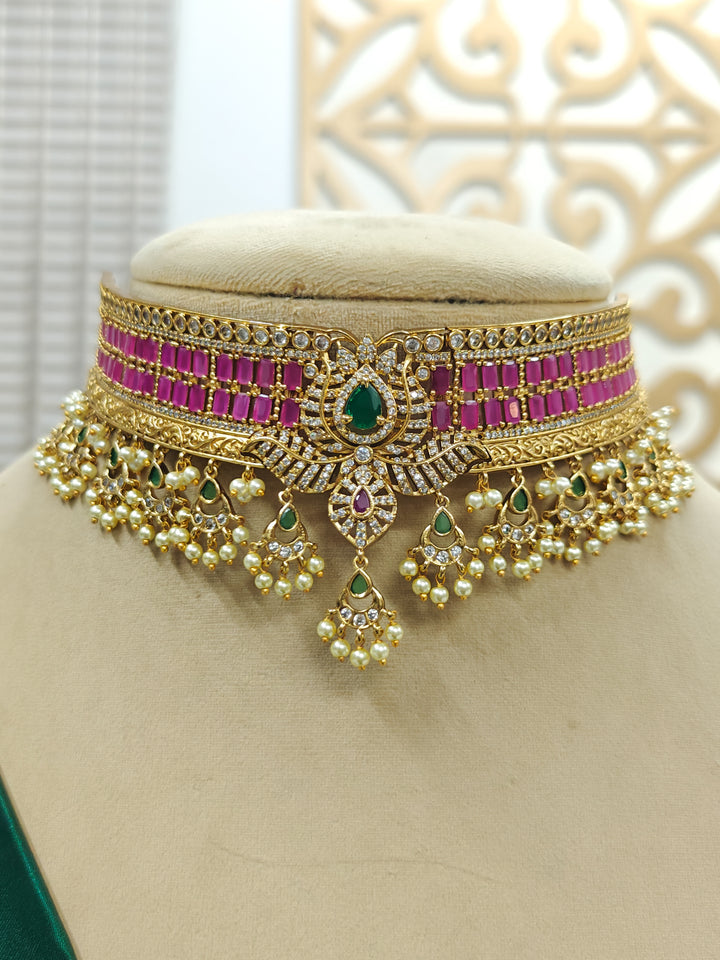 Close-up of an ornate traditional American Diamond gold Pink Choker jewellery set and earrings with  Colored Stones, American Diamond and Pearls. Close-up shot of a high-quality American diamond artificial necklace worn for festive celebrations. Bride wearing a sparkling American diamond necklace for her reception night.