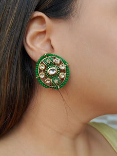 Close-up of a woman wearing an ornate traditional Green Kundan Studs Earrings with Kundan, Meenakari and Green Crystal Beads. Mehendi ceremony look completed with a handcrafted Kundan Earrings. Close-up of detailed enamel craftsmanship in Kundan Earrings.