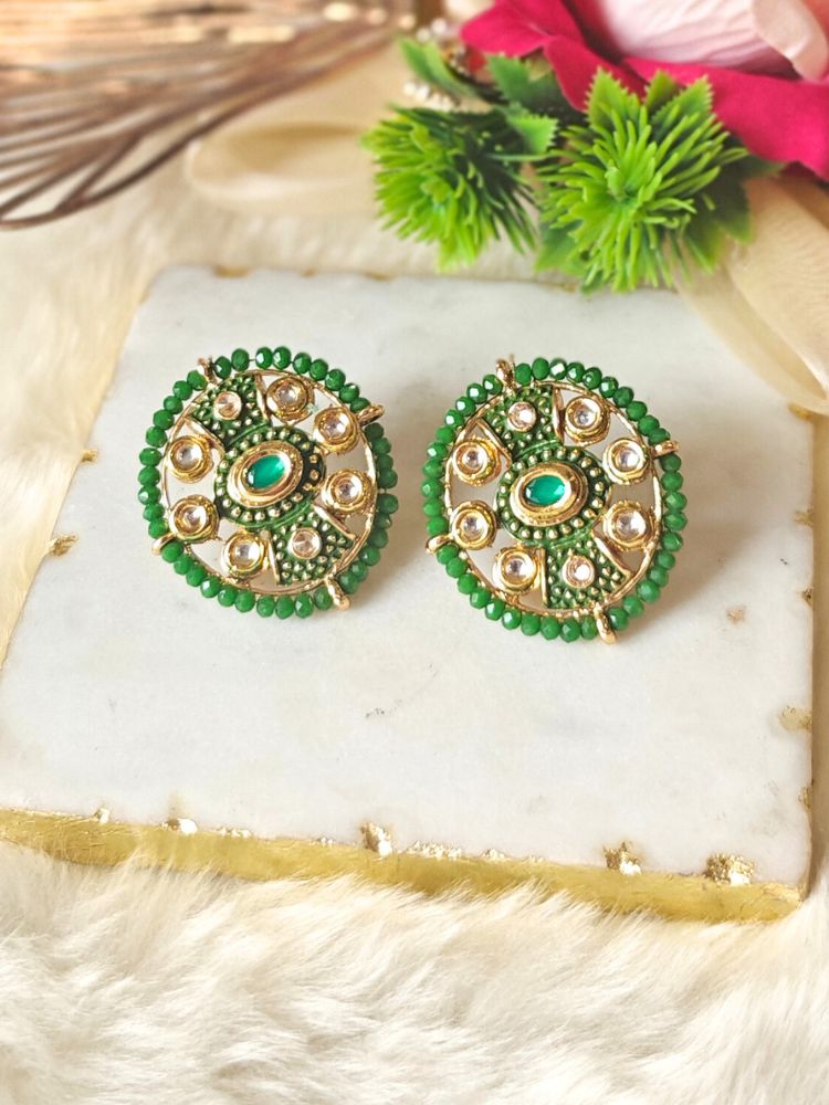 Close-up of an ornate traditional Green Meenakari Studs Earrings with Kundan, Meenakari and Green Crystal Beads. Mehendi ceremony look completed with a handcrafted Meenakari Earrings. Close-up of detailed enamel craftsmanship in Meenakari Earrings.