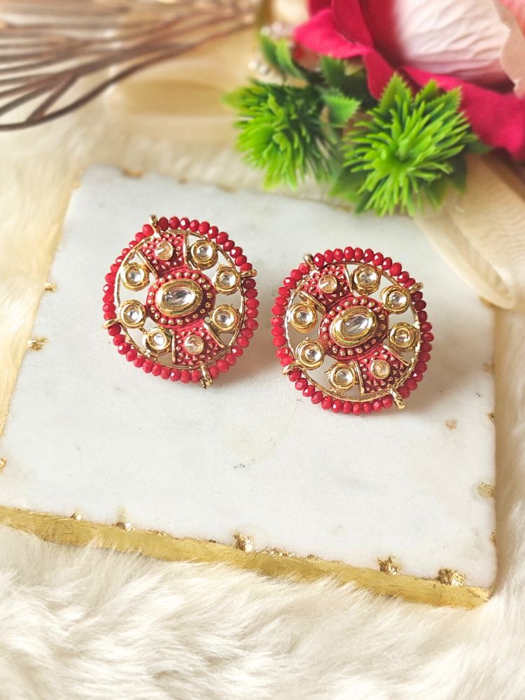 Close-up of an ornate traditional Red Meenakari Studs Earrings with Kundan, Meenakari and Red Crystal Beads. Mehendi ceremony look completed with a handcrafted Meenakari Earrings. Close-up of detailed enamel craftsmanship in Meenakari Earrings.