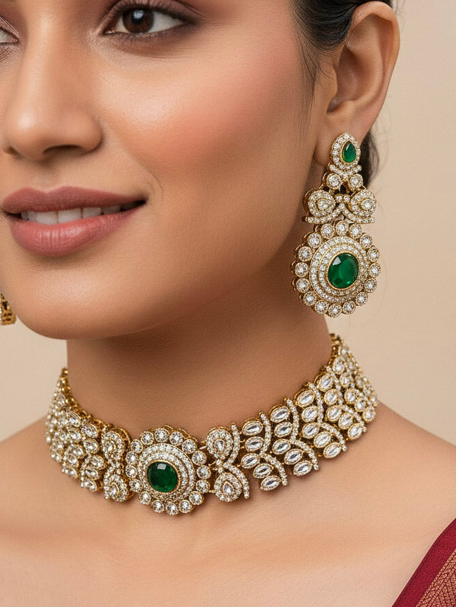 Close-up of a woman wearing an ornate traditional Green Diamond gold Polish Choker jewellery set and earrings and maangtikka with American Diamond and Green Colored Stones. A woman wearing a luxury American diamond necklace set styled beautifully for a wedding guest look in India. Mehendi function outfit styled with a lightweight American Diamond Necklace.