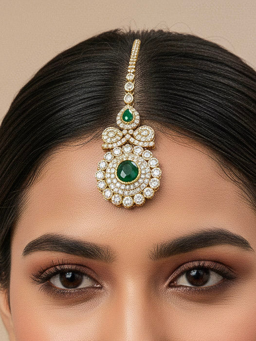 Close-up of a woman wearing an ornate traditional Green Diamond gold Polish Choker jewellery set and earrings and maangtikka with American Diamond and Green Colored Stones. A woman wearing a luxury American diamond necklace set styled beautifully for a wedding guest look in India. Mehendi function outfit styled with a lightweight American Diamond Necklace.