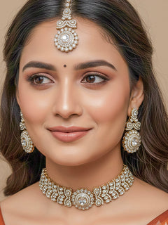 Close-up of a woman wearing an ornate traditional White Diamond gold Polish Choker jewellery set and earrings and maangtikka with American Diamond. A woman wearing a luxury American diamond necklace set styled beautifully for a wedding guest look in India. Mehendi function outfit styled with a lightweight American Diamond Necklace.