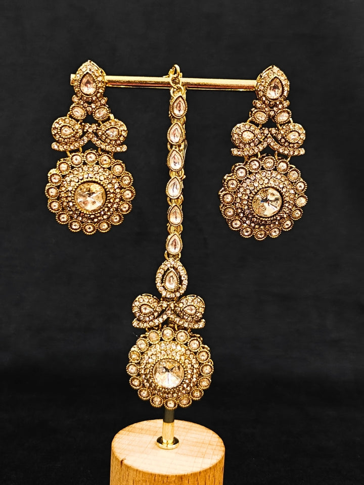 Close-up of an ornate traditional White Diamond gold Polish Choker jewellery set and earrings and maangtikka with American Diamond. A luxury American diamond necklace set styled beautifully for a wedding guest look in India. Mehendi function outfit styled with a lightweight American Diamond Necklace.