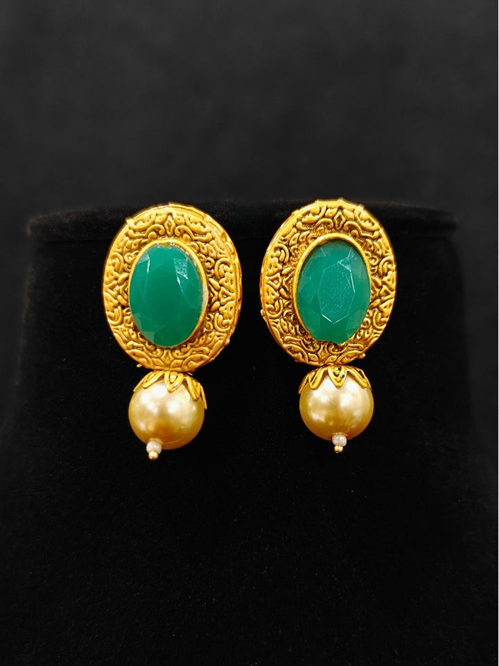 Close-up of an ornate traditional (Gold Polish) Long jewellery set and earrings with Kundan, Colored Stones and Pearls. Wedding guest look featuring a Long imitation Pearl jewelry set. Traditional Indian wedding look featuring a bridal Long set.