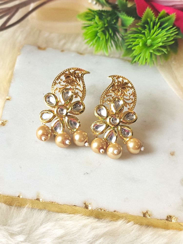 Close-up of a woman wearing an ornate traditional (Gold Polish) Earrings with Kundan, Filigree Work and Pearls. Close-up of anti-tarnish artificial Kundan earrings for festive celebrations. Festive Diwali look styled with premium artificial Kundan earrings.