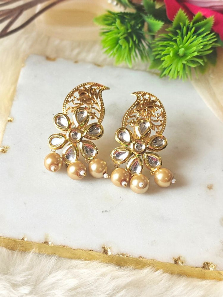 Close-up of a woman wearing an ornate traditional (Gold Polish) Earrings with Kundan, Filigree Work and Pearls. Close-up of anti-tarnish artificial Kundan earrings for festive celebrations. Festive Diwali look styled with premium artificial Kundan earrings.