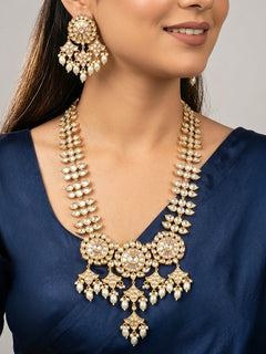 Close-up of a woman wearing an ornate traditional (Gold Polish) Long jewellery set and earrings with Polki and Pearls. Festive saree look completed with a Long Polki artificial jewelry set. Woman wearing trending Polki artificial jewelry for the wedding season in India.