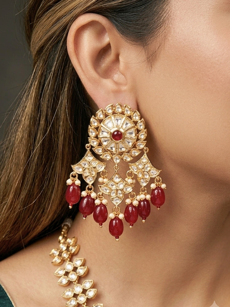 Close-up of a woman wearing an ornate traditional (Gold Polish) Ruby Red Long jewellery set and earrings with Polki, Colored Stone and Red Tumble Beads. Festive saree look completed with a Long Polki artificial jewelry set. Woman wearing trending Polki artificial jewelry for the wedding season in India.