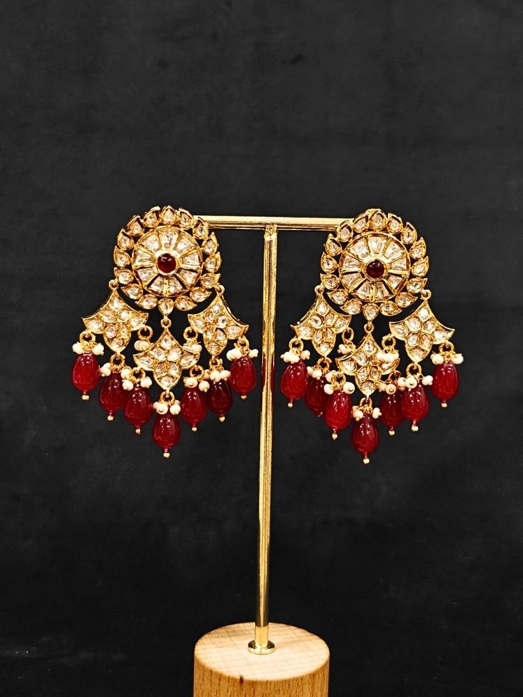 Close-up of an ornate traditional (Gold Polish) Ruby Red Long jewellery set and earrings with Polki, Colored Stone and Red Tumble Beads. Festive saree look completed with a Long Polki artificial jewelry set. Woman wearing trending Polki artificial jewelry for the wedding season in India.