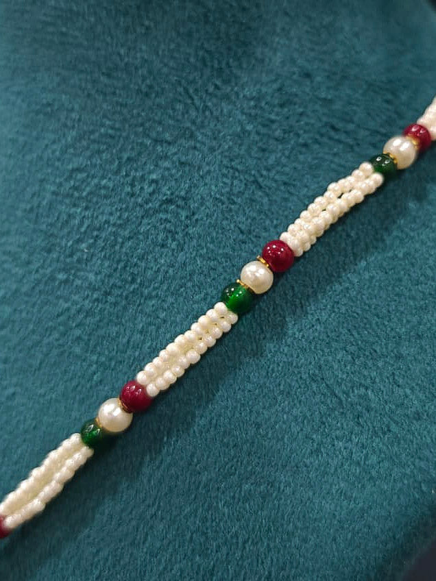 Close-up of an ornate traditional Multi-color jadau gold Pendant set and jadau earrings with pearls, Beads and Color Stone. Elegant look featuring a luxury Jadau artificial Pendant set. Festive look completed with a handcrafted Jadau Pendant.