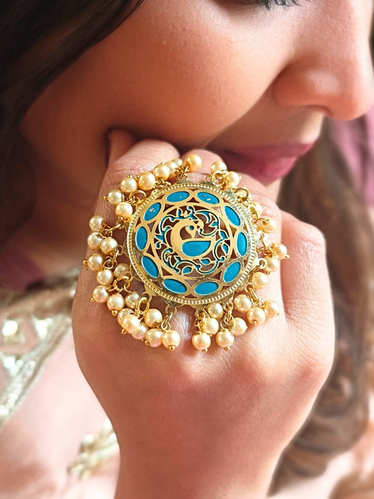 Close-up of a woman wearing an ornate traditional (Gold Polish) Blue Ring with Pearls and Meenakari. Woman styling a premium imitation Pearl ring with festive attire. Bridal mehendi outfit paired with a luxury artificial Pearl ring.