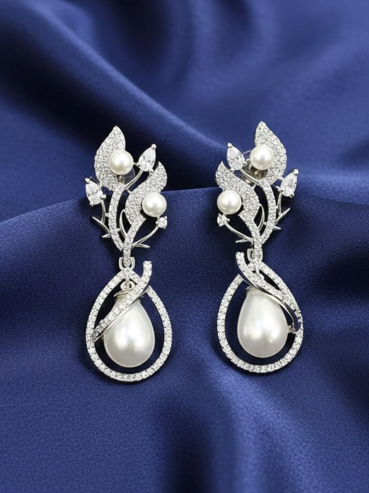 Close-up of an ornate Western (Silver Polish) White Earrings with American Diamond and Pearls. Elegant festive look with a high-quality imitation American diamond Earrings. Reception-ready look featuring a statement American diamond Earrings.
