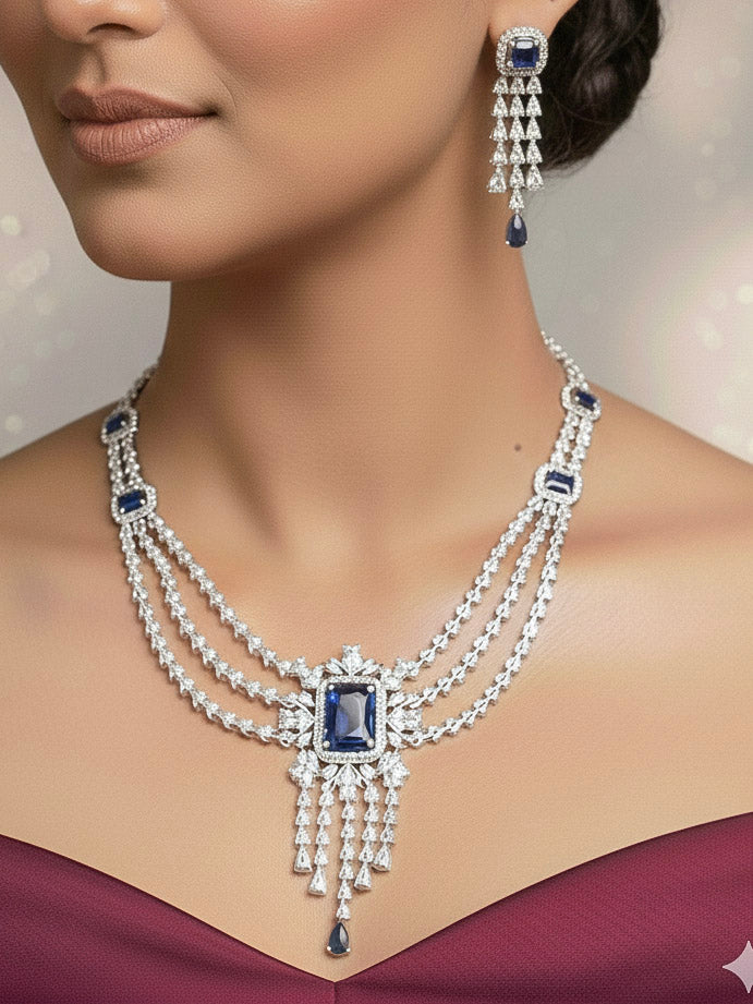"A beautiful woman wearing an elegant artificial diamond necklace with navy blue colored stone and matching earrings with maangtikka. This premium artificial diamond jewelry set is perfect for special occasions, from Indian weddings to engagement parties, offering sophisticated glamour without the high price tag."

