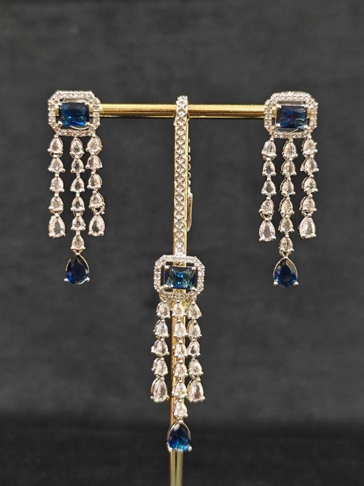 Close-up of an ornate Indo-western Navy Blue Diamond Silver Collar jewellery set and earrings and maangtikka with American Diamond & Colored Stones. Close-up shot of a high-quality American diamond artificial necklace worn for festive celebrations. A sparkling American diamond necklace for reception night.