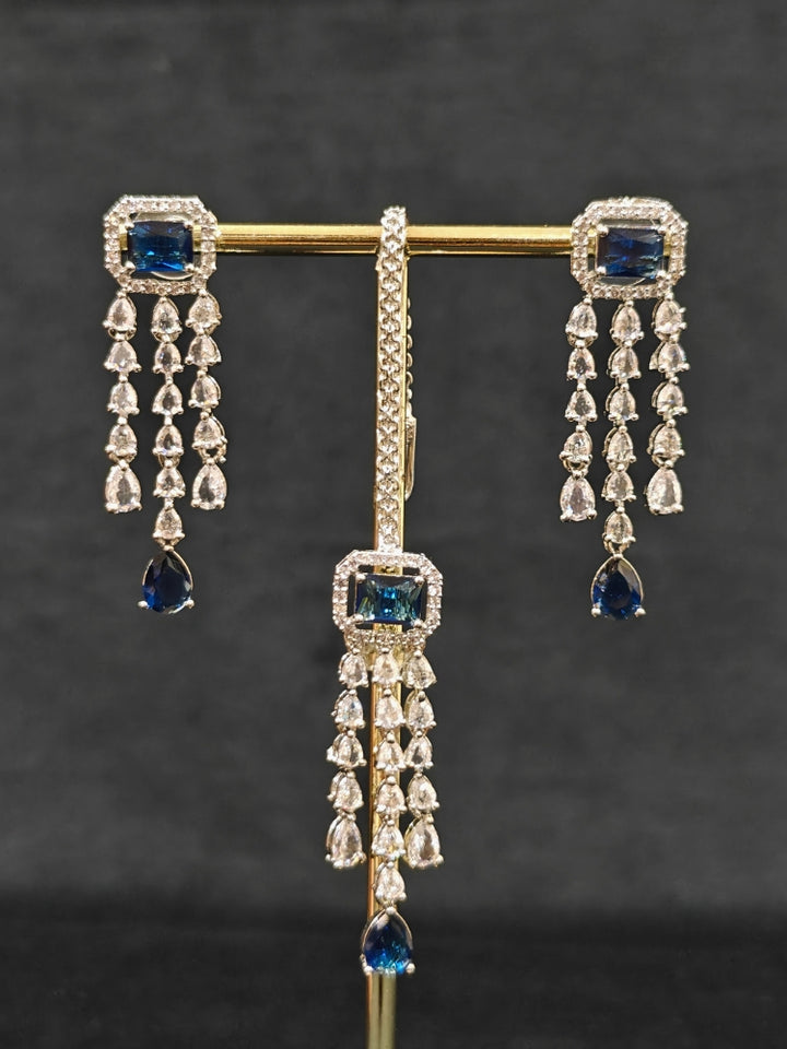Close-up of an ornate Indo-western Navy Blue Diamond Silver Collar jewellery set and earrings and maangtikka with American Diamond & Colored Stones. Close-up shot of a high-quality American diamond artificial necklace worn for festive celebrations. A sparkling American diamond necklace for reception night.