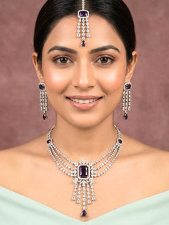 Close-up of a woman wearing an ornate Indo-western Purple Diamond Silver Collar jewellery set and earrings and maangtikka with American Diamond & Colored Stones. Close-up shot of a high-quality American diamond artificial necklace worn for festive celebrations. Bride wearing a sparkling American diamond necklace for her reception night.