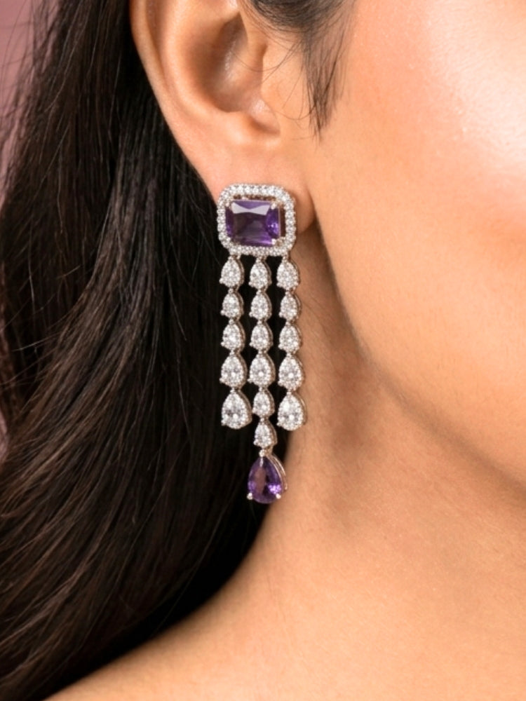 Close-up of a woman wearing an ornate Indo-western Purple Diamond Silver Collar jewellery set and earrings and maangtikka with American Diamond & Colored Stones. Close-up shot of a high-quality American diamond artificial necklace worn for festive celebrations. Bride wearing a sparkling American diamond necklace for her reception night.