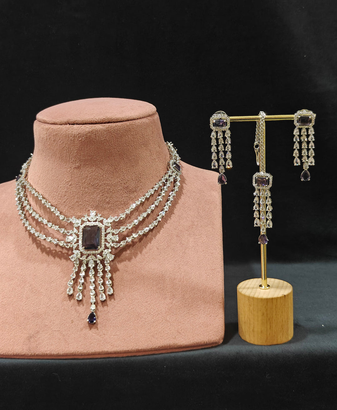 Close-up of an ornate Indo-western Purple Diamond Silver Collar jewellery set and earrings and maangtikka with American Diamond & Colored Stones. Close-up shot of a high-quality American diamond artificial necklace worn for festive celebrations. A sparkling American diamond necklace for reception night.