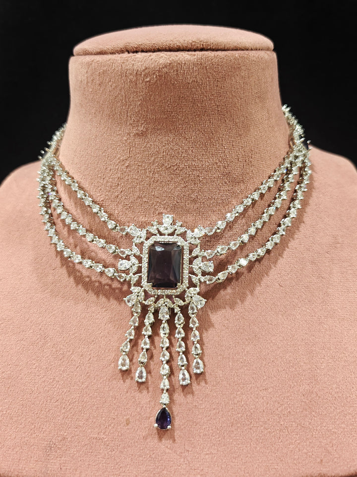 Close-up of an ornate Indo-western Purple Diamond Silver Collar jewellery set and earrings and maangtikka with American Diamond & Colored Stones. Close-up shot of a high-quality American diamond artificial necklace worn for festive celebrations. A sparkling American diamond necklace for reception night.