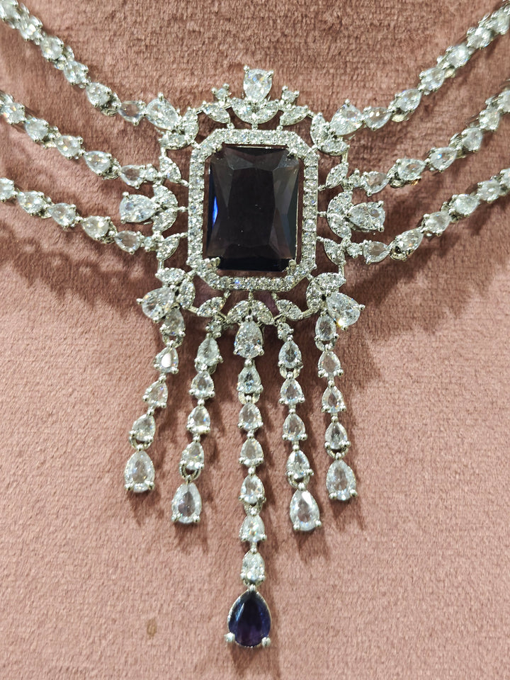 Close-up of an ornate Indo-western Purple Diamond Silver Collar jewellery set and earrings and maangtikka with American Diamond & Colored Stones. Close-up shot of a high-quality American diamond artificial necklace worn for festive celebrations. A sparkling American diamond necklace for reception night.