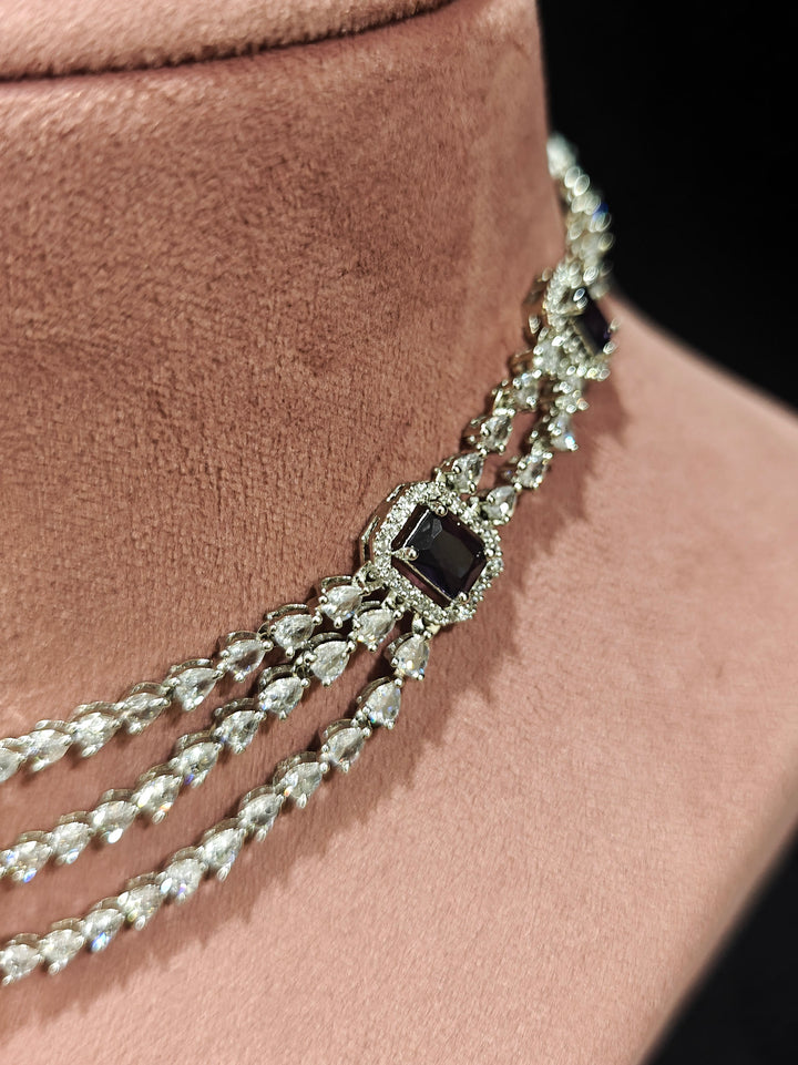Close-up of an ornate Indo-western Purple Diamond Silver Collar jewellery set and earrings and maangtikka with American Diamond & Colored Stones. Close-up shot of a high-quality American diamond artificial necklace worn for festive celebrations. A sparkling American diamond necklace for reception night.