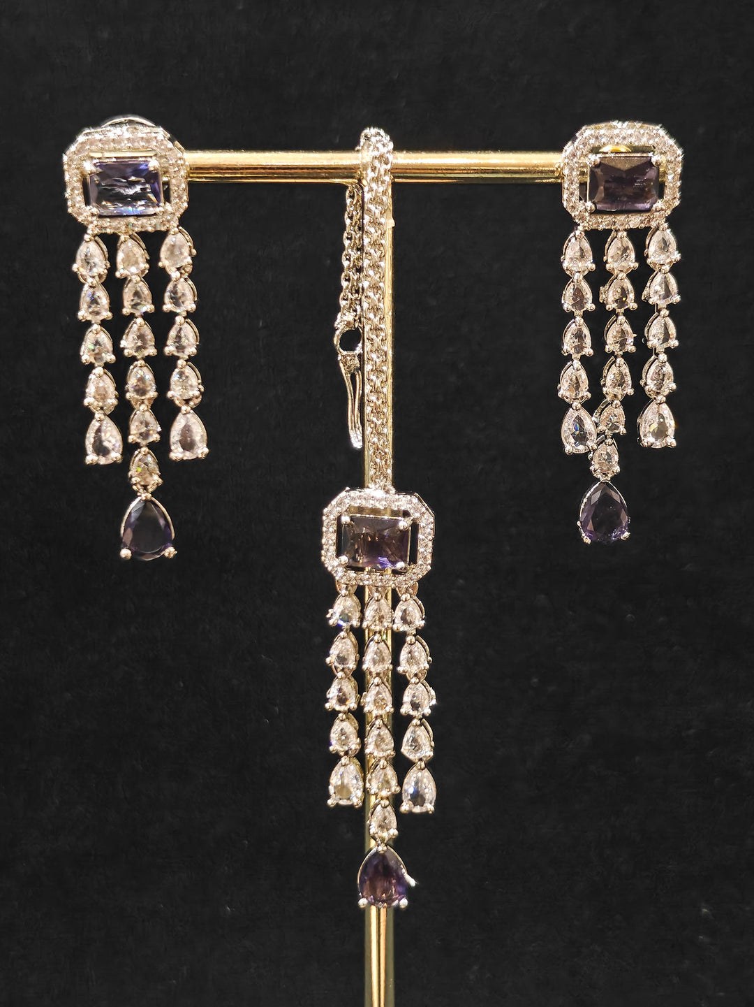 Close-up of an ornate Indo-western Purple Diamond Silver Collar jewellery set and earrings and maangtikka with American Diamond & Colored Stones. Close-up shot of a high-quality American diamond artificial necklace worn for festive celebrations. A sparkling American diamond necklace for reception night.