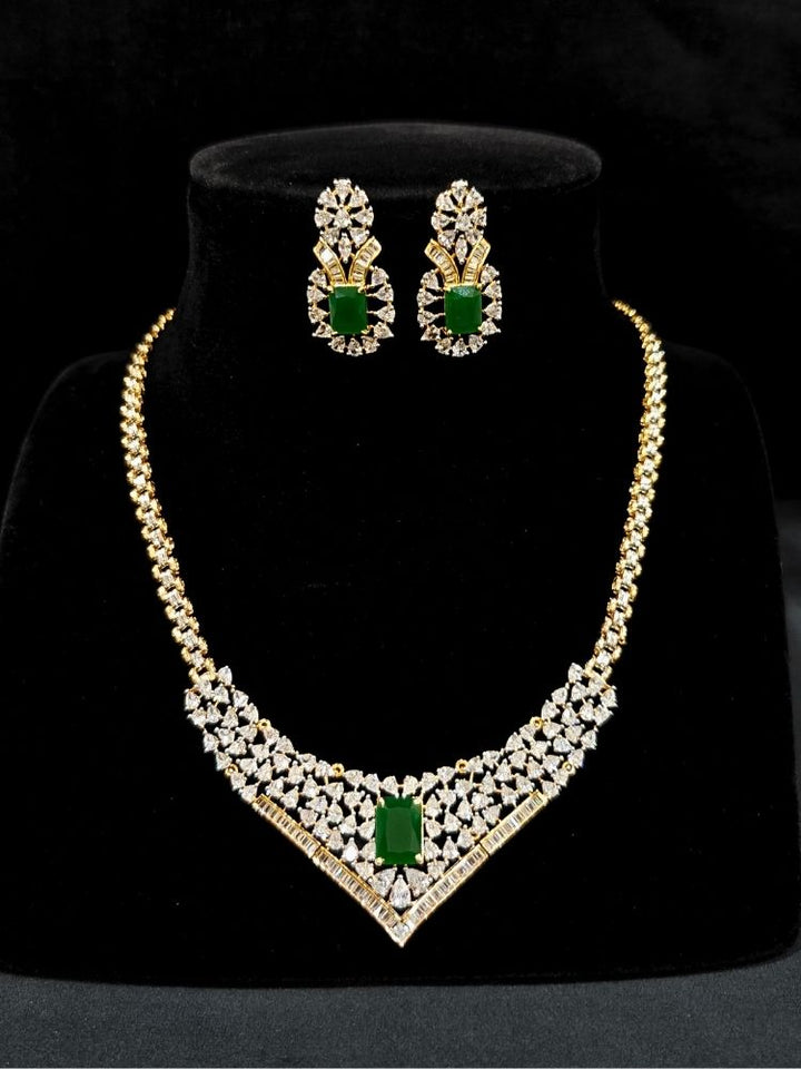 Close-up of an ornate Western (Silver Polish) Green Collar jewellery set and earrings with Green Colored Stone and American Diamond. Woman styling a statement American diamond necklace with an off-shoulder gown for a reception. Party wear outfit completed with a lightweight American diamond necklace.