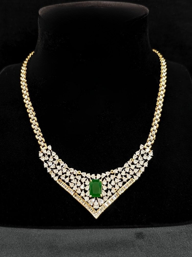 Close-up of an ornate Western (Silver Polish) Green Collar jewellery set and earrings with Green Colored Stone and American Diamond. Woman styling a statement American diamond necklace with an off-shoulder gown for a reception. Party wear outfit completed with a lightweight American diamond necklace.