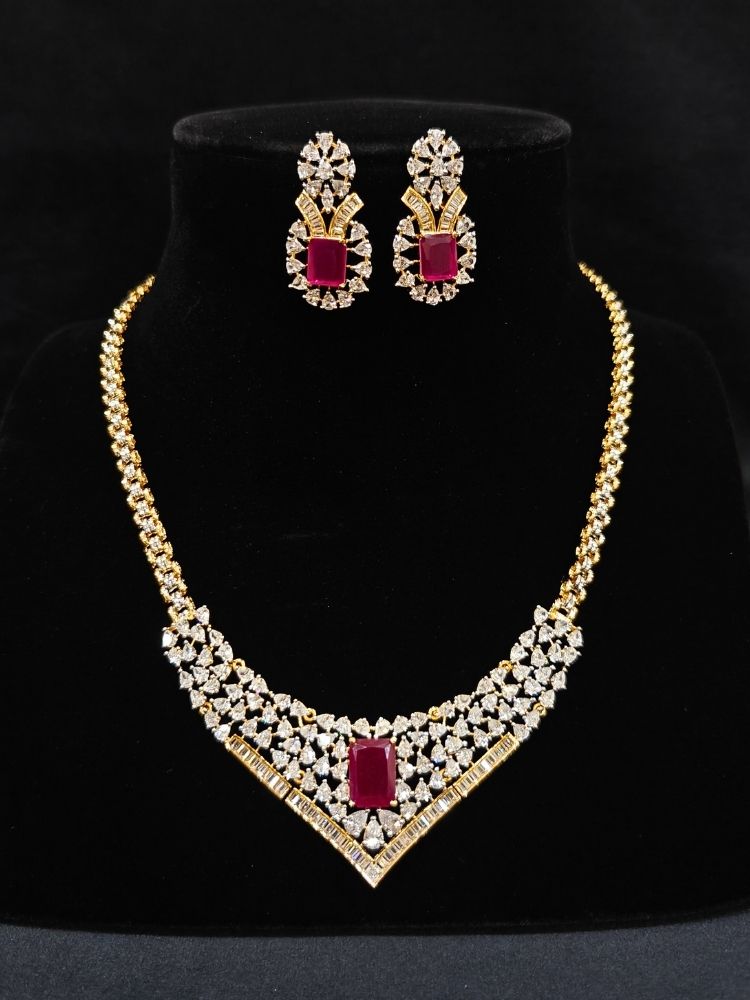Close-up of an ornate Western (Silver Polish) Pink Collar jewellery set and earrings with Pink Colored Stone and American Diamond. Woman styling a statement American diamond necklace with an off-shoulder gown for a reception. Party wear outfit completed with a lightweight American diamond necklace.