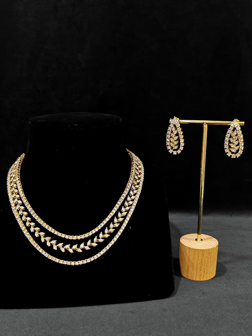 Close-up of an ornate Indo-Western American Diamond gold Layered Collar jewellery set and earrings with American Diamond. Close-up of a cocktail party look featuring a premium American diamond necklace. Party wear outfit completed with a lightweight American diamond necklace.