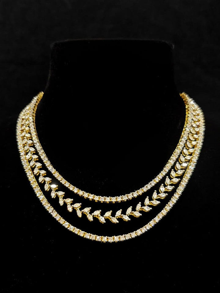 Close-up of an ornate Indo-Western American Diamond gold Layered Collar jewellery set and earrings with American Diamond. Close-up of a cocktail party look featuring a premium American diamond necklace. Party wear outfit completed with a lightweight American diamond necklace.