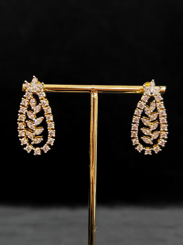 Close-up of an ornate Indo-Western American Diamond gold Layered Collar jewellery set and earrings with American Diamond. Close-up of a cocktail party look featuring a premium American diamond necklace. Party wear outfit completed with a lightweight American diamond necklace.