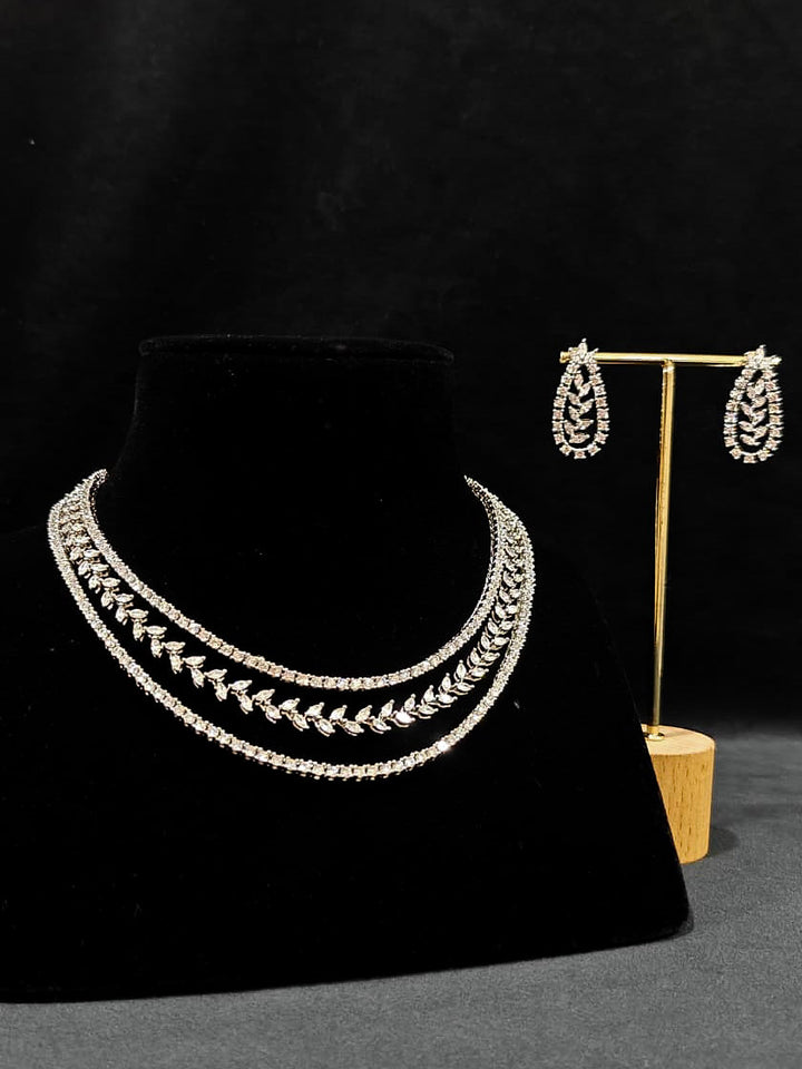 Close-up of an ornate Indo-Western American Diamond Silver Layered Collar jewellery set and earrings with American Diamond. Close-up of a cocktail party look featuring a premium American diamond necklace. Party wear outfit completed with a lightweight American diamond necklace.