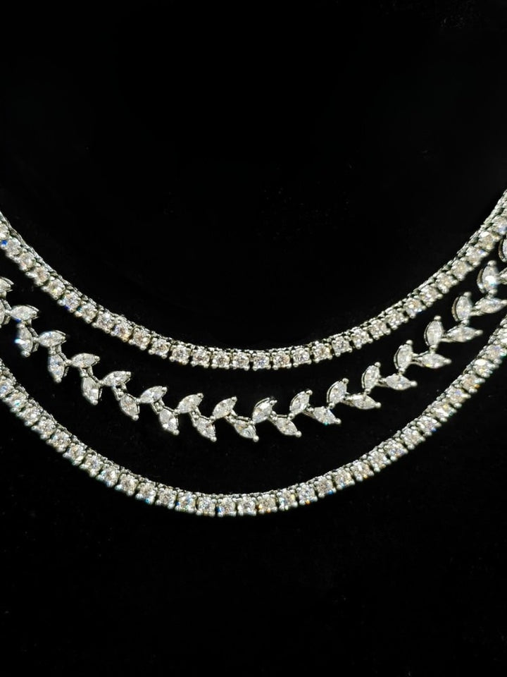 Close-up of an ornate Indo-Western American Diamond Silver Layered Collar jewellery set and earrings with American Diamond. Close-up of a cocktail party look featuring a premium American diamond necklace. Party wear outfit completed with a lightweight American diamond necklace.