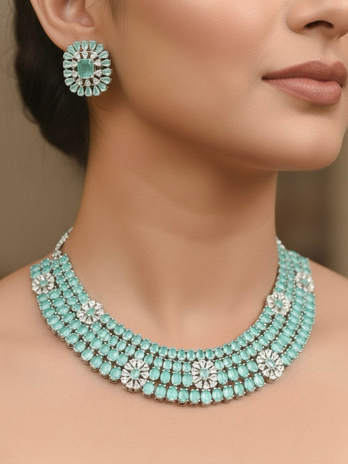 "A bride-to-be wearing an exquisite artificial diamond necklace with mint green colored stone and matching earrings, designed for the perfect engagement look. This stunning artificial diamond jewelry set offers luxury and sophistication while being an affordable alternative to natural diamonds."