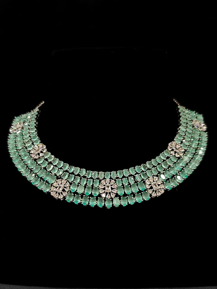 "An exquisite artificial diamond necklace with mint green colored stone and matching earrings, designed for the perfect engagement look. This stunning artificial diamond jewelry set offers luxury and sophistication while being an affordable alternative to natural diamonds." Reception-ready look featuring a statement American diamond jewelry set.