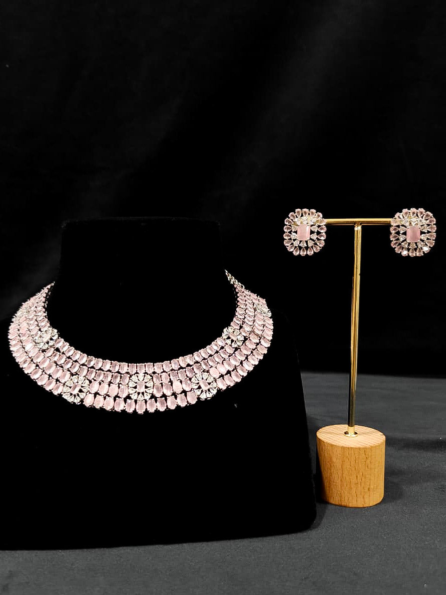 "A glamorous artificial diamond necklace with mint pink colored stone paired with chic earrings, perfect for bridal wear. This high-quality artificial diamond jewelry set is the ideal choice for modern brides looking for a budget-friendly option with timeless sparkle." Reception-ready look featuring a statement American diamond jewelry set.