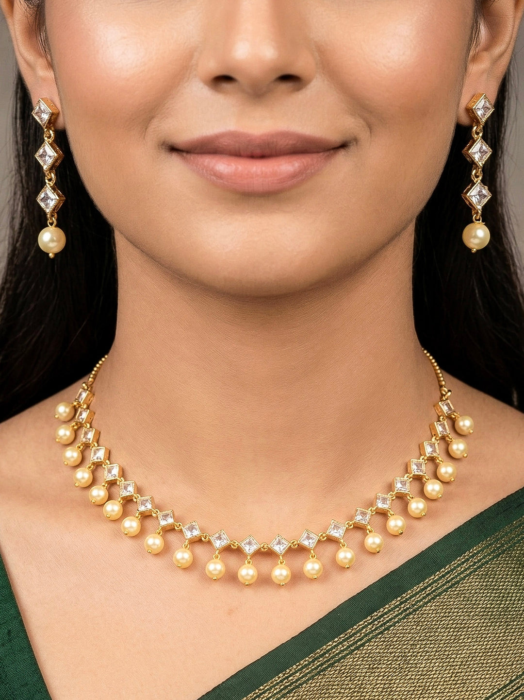 Close-up of a woman wearing an ornate traditional (Gold Polish) Collar jewellery set and earrings with American Diamond Polki and Pearls. Elegant festive look with a high-quality imitation American diamond necklace set. Festive Diwali outfit styled with an American diamond artificial necklace.