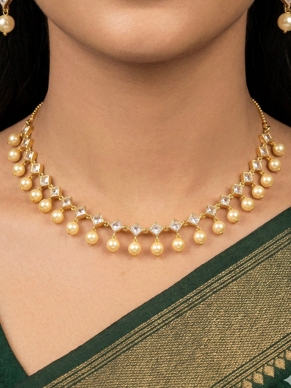 Close-up of a woman wearing an ornate traditional (Gold Polish) Collar jewellery set and earrings with American Diamond Polki and Pearls. Elegant festive look with a high-quality imitation American diamond necklace set. Festive Diwali outfit styled with an American diamond artificial necklace.