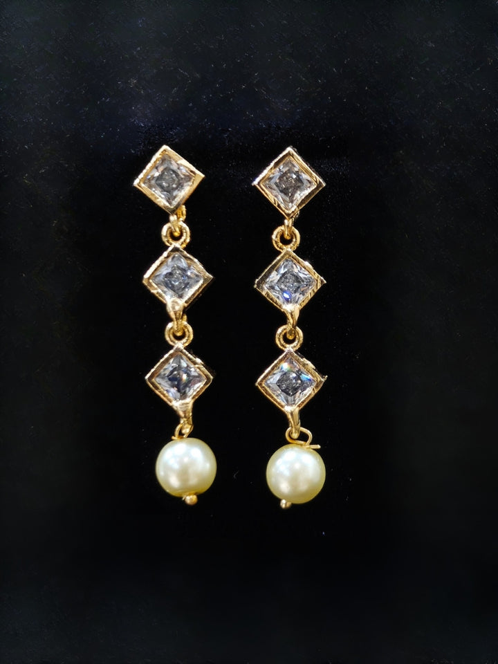 Close-up of an ornate traditional (Gold Polish) Collar jewellery set and earrings with American Diamond Polki and Pearls. Elegant festive look with a high-quality imitation American diamond necklace set. Festive Diwali outfit styled with an American diamond artificial necklace.