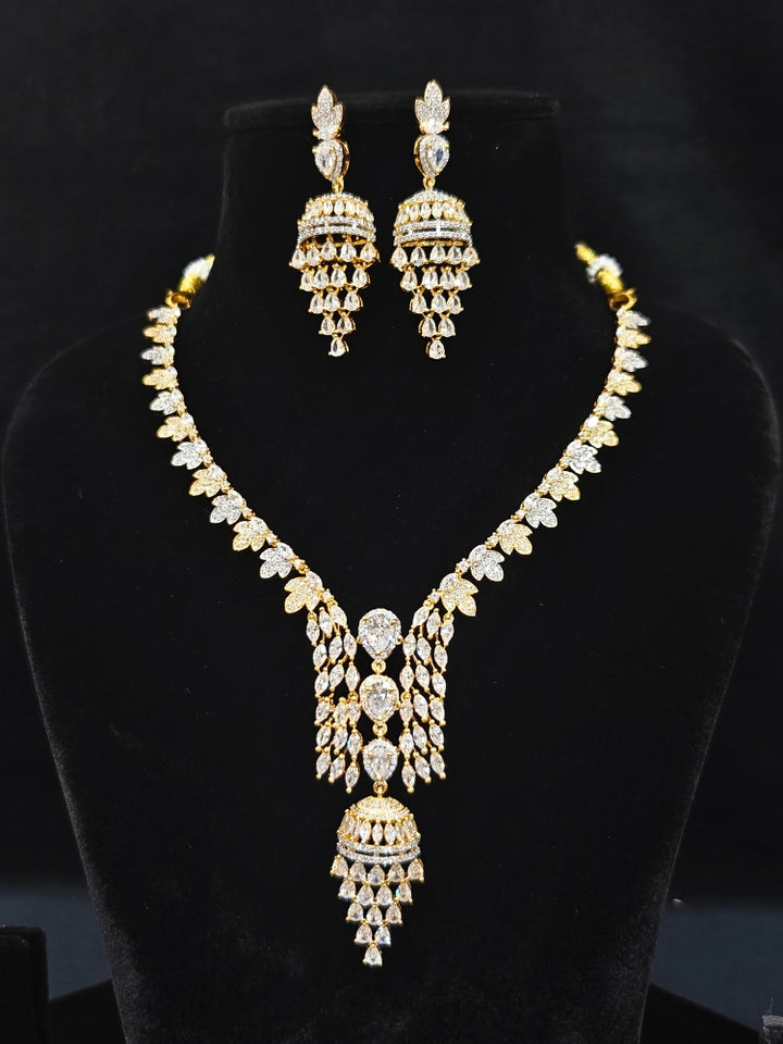 Close-up of an ornate Western American Diamond gold & White Collar jewellery set and earrings with American Diamond. Party wear outfit completed with a lightweight American diamond necklace. Elegant Cocktail and Party jewelry look featuring a premium artificial American diamond necklace.