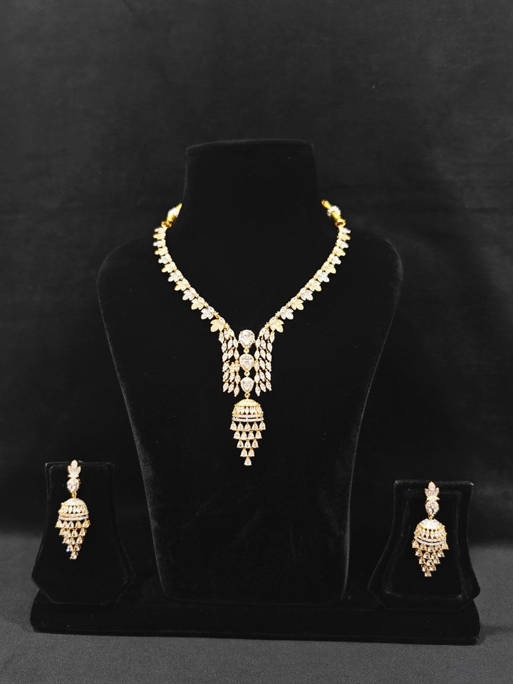 Close-up of an ornate Western American Diamond gold & White Collar jewellery set and earrings with American Diamond. Party wear outfit completed with a lightweight American diamond necklace. Elegant Cocktail and Party jewelry look featuring a premium artificial American diamond necklace.