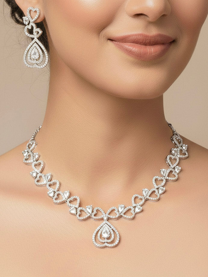 Close-up of a woman wearing an ornate Western (Silver Polish) Collar Diamond  jewellery set and earrings American Diamond. Reception-ready look featuring a statement American diamond jewelry set. Party wear outfit completed with a lightweight American diamond necklace.