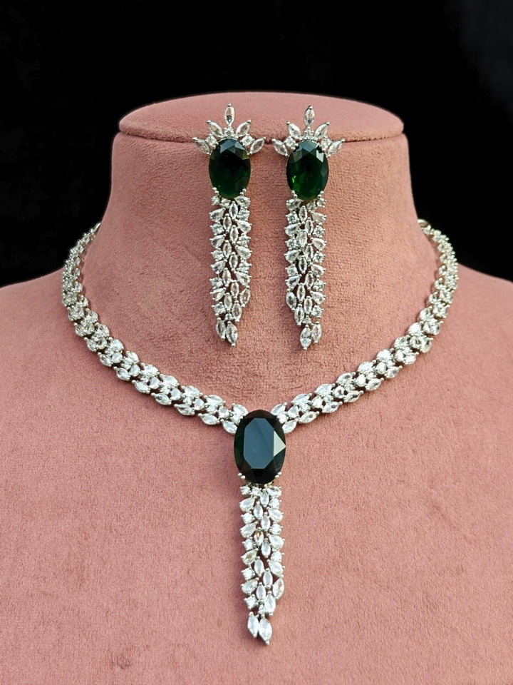 Close-up of an ornate Western Dark Green (Silver Polish) Collar Diamond jewellery set and earrings with Dark Green Colored Stone and American Diamond. Party wear outfit completed with a lightweight American diamond necklace.
Perfect American Diamond necklace set for Cocktail Party and festivals.