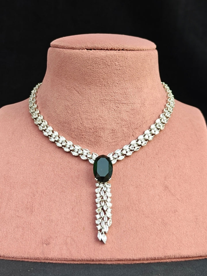 Close-up of an ornate Western Dark Green (Silver Polish) Collar Diamond jewellery set and earrings with Dark Green Colored Stone and American Diamond. Party wear outfit completed with a lightweight American diamond necklace.
Perfect American Diamond necklace set for Cocktail Party and festivals.