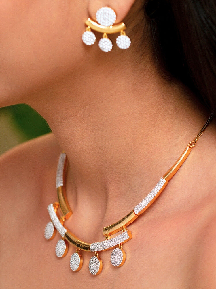 The Lunessa Necklace Set features gold and white tones with round American Diamonds, sparkling atop black velvet. This elegant accessory for cocktail gowns comes beautifully presented in a golden box.